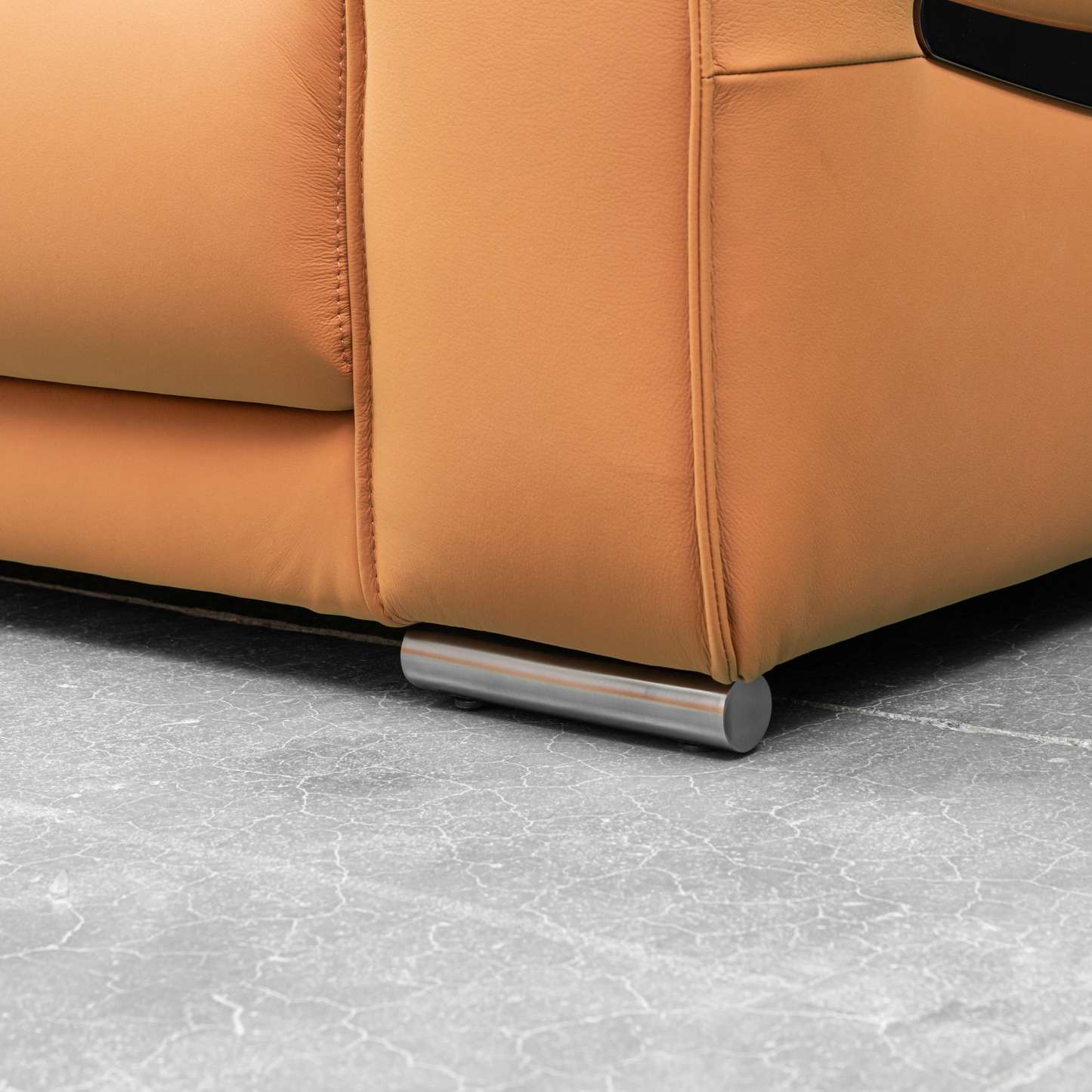 Close-up of Klaussner Grazia orange leather chair with sleek metal legs and track arms, showcasing fine stitching and premium upholstery.
