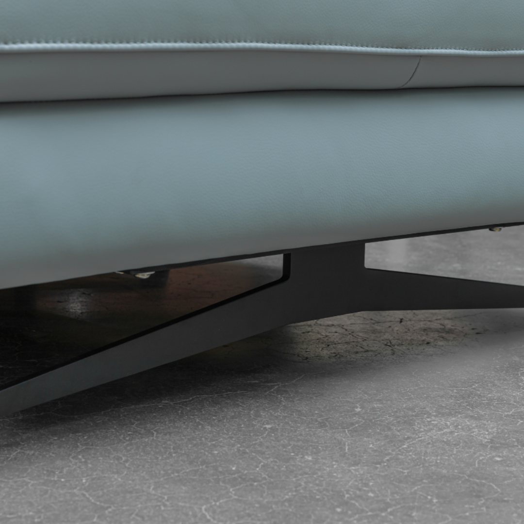Detail shot of light blue leather sectional sofa showing black metal leg base with floor clearance for easy cleaning underneath for comfort design furniture