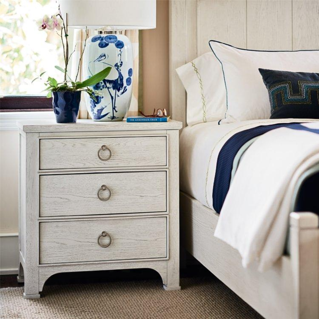Enhance your bedroom with the Escape Nightstand, featuring a clean coastal design in a sandbar finish. This 3-drawer piece offers simple lines, durable construction, and elegant ring-pull hardware for timeless style and function.