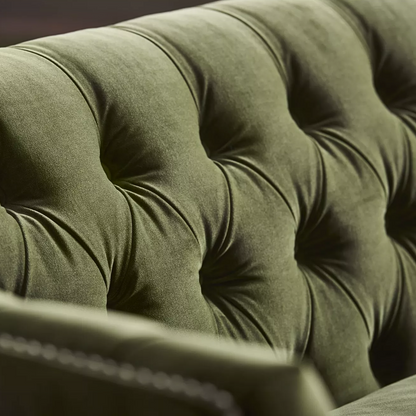 Closeup view of Duncan Tufted Sofa in green  upholstery with deep button-tufting, nailhead trim, and wooden legs – elegant 2-seater design