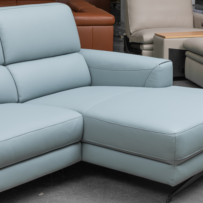 Close-up corner view of light blue leather sectional sofa showing L-shaped configuration with plush cushioned seating and clean modern lines for comfort design furniture
